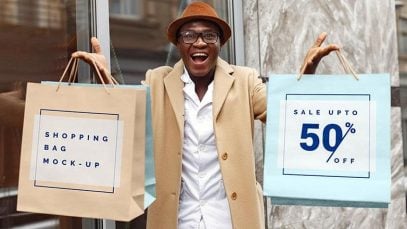 Free-Excited-Man-Hand-Holding-Shopping-Bags-Mockup-PSD-File